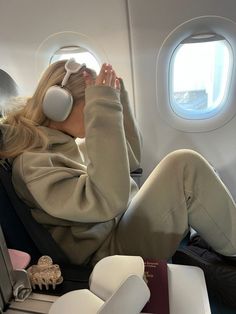 a woman sitting in an airplane with headphones on