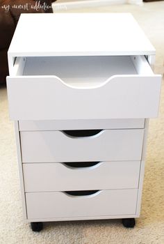 a white dresser sitting on top of a carpeted floor