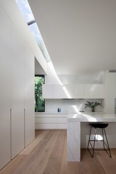 a kitchen with white cabinets and wooden floors