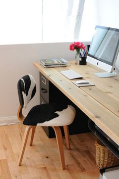 a desk with a computer, keyboard and mouse on it in front of a window