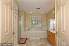 a large bathroom with two sinks and a bathtub next to a walk in shower