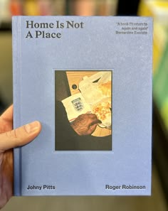 a person holding up a book about home is not a place