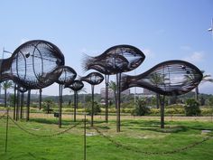 several metal sculptures in the middle of a grassy field