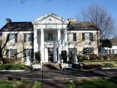 a large white house sitting on top of a lush green field