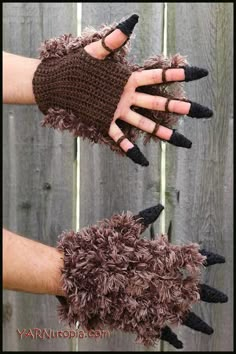 two hands wearing black and brown knitted gloves with fake nails on their fingertipss