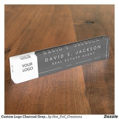 a business name tag sitting on top of a wooden table