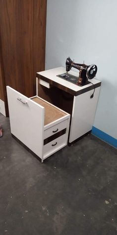 an old sewing machine sits on top of a cabinet