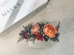 a hair comb with flowers on it next to a box