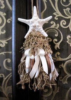 a starfish hanging on a door with some ribbons and other things attached to it