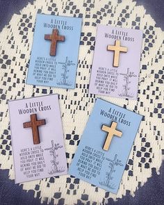 four little wooden crosses are on a doily