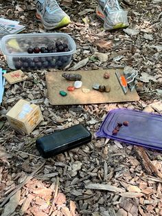 an assortment of items laying on the ground next to some shoes and other things in plastic containers