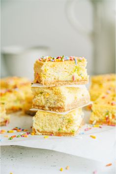 three pieces of cake stacked on top of each other with sprinkles around them