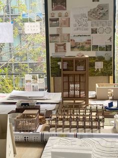 a room filled with lots of desks and chairs next to a wall covered in pictures