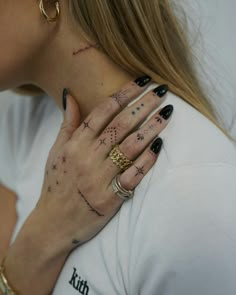 a woman with tattoos on her neck and hand is holding onto the other side of her neck