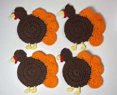 four crocheted turkey coasters on a white surface