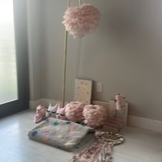 a baby crib with pink pom - poms and other items on the floor