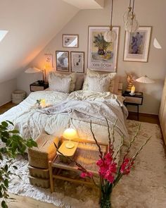 a bedroom with white bedding and lots of flowers on the table in front of it