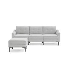 a white couch and footstool sitting next to each other on a white background