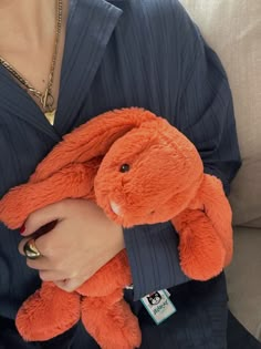 a woman holding an orange stuffed animal in her lap