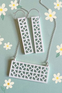 A set of two white laser cut acrylic drop earrings in breeze block pattern, on sterling silver hoops. Below the earrings is a matching breeze block necklace, also made from white acrylic. The jewellery is set against a pale green background with daisy graphics scattered around. Breeze Block Wall, Spring Birthday, Spring Jewelry, Block Wall, Jewellery Ideas, Party Style, White Acrylic