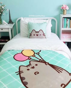 a bed with a cartoon cat on the cover and pillow cases in front of it