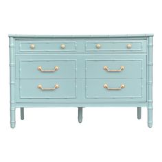 a blue dresser with gold knobs on the top and bottom drawers, against a white background