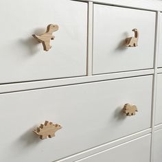 a white dresser with wooden handles and knobs