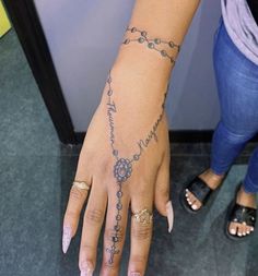 a woman's hand with a rosary tattoo on it