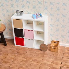 a toy room with a book shelf and wooden stools on the floor next to a wallpapered wall