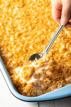 a person spooning some food out of a casserole dish