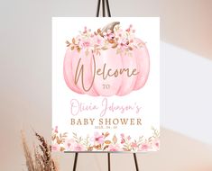 a welcome sign for a baby shower with pink pumpkins and flowers on the front