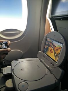 someone is playing a video game on an airplane