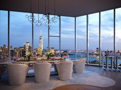 a dining room with large windows overlooking the city