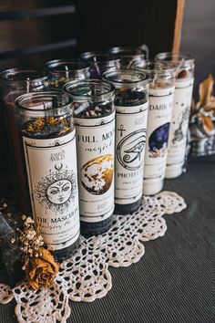 several jars filled with different types of spices sitting on a doily next to each other