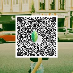 a person sitting on the ground holding up a qr - code to their face