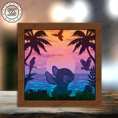 a wooden frame with an image of a cat and birds on the beach at sunset