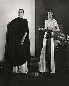 two women standing next to each other in black and white