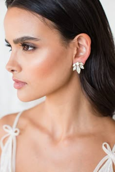 a woman wearing earrings with bows on the back of her head and one ear is shown