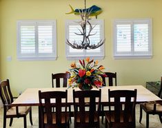 a dining room table with chairs and a vase filled with flowers