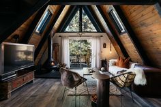 a living room filled with furniture and a flat screen tv on top of a wooden floor