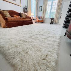 a living room with a large white rug on the floor