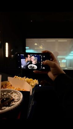 a person taking a photo of food with their cell phone in front of the camera