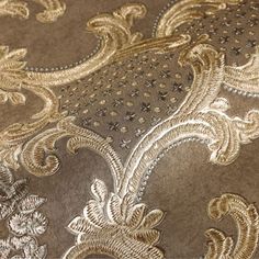 closeup of the gold and silver fabric on a bed sheet that has been made to look like an intricate design