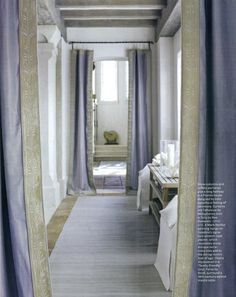 an open door leading to a bedroom with blue curtains