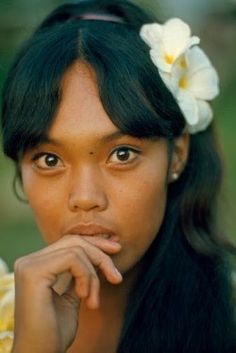 a woman with flowers in her hair posing for the camera