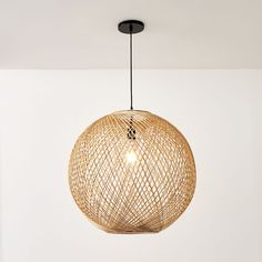 a round light fixture hanging from the ceiling in a room with white walls and flooring