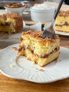 a piece of cake on a white plate with a fork stuck in the top slice