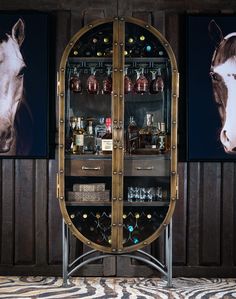 a horse head is on the wall behind a wine cabinet