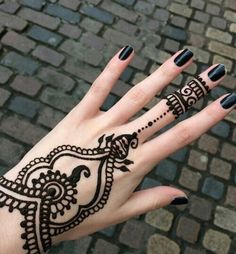 a woman's hand with henna tattoos on it