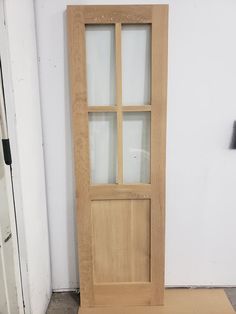 a wooden door sitting next to a white wall